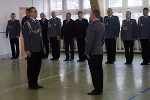 Na zdjęciu mężczyzna w policyjnym mundurze podinsp. Tomasz Sroka składa meldunek  pierwszemu Zastępcy Komendanta Wojewódzkiego Policji w Katowicach insp. Romanowi Rabsztynowi.