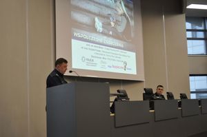 Na zdjęciu policjant wygłaszający referat z mównicy.