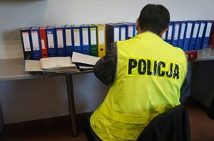 Policjant podczas czynności służbowych i przeglądania dokumentacji
