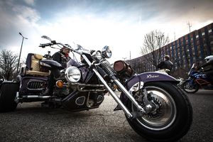 Motocyklista siedzący na trajce na tle KWP w Katowicach