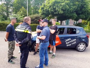 Polscy i holenderscy policjanci rozmawiają z Polakami pracującymi w Holandii podczas kontroli miejsc ich pracy i zamieszkania.