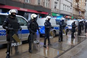 na zdjęciu umundurowani policjanci zabezpieczający przemarsz kibiców