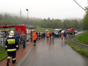 Zdjęcie przedstawia strażaków, policjantów oraz osoby obserwujące okolice zapory w Wilkowicach