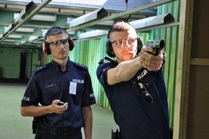 Instruktor strzelań policyjnych wraz z policjantem biorącym udział w turnieju par patrolowych, podczas konkurencji na strzelnicy