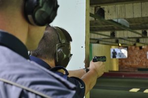 Instruktor strzelań policyjnych wraz z policjantem biorącym udział w turnieju par patrolowych, podczas konkurencji na strzelnicy