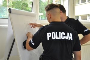 Policjanci analizujący wyniki poszczególnych konkurencji podczas wojewódzkich eliminacji do Ogólnopolskich Zawodów Policjantów Prewencji Turniej Par Patrolowych „Patrol Roku 2019”