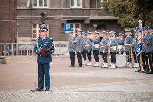 Komendant Główny Policji gen. insp. dr Jarosław Szymczyk podczas przemówienia z okazji Wojewódzkich Obchodów Święta Policji w Katowicach. W tle Orkiestra Komendy Wojewódzkiej Policji w Katowicach