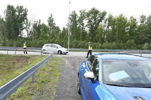 Policjanci w trakcie kontroli drogowej. Widoczny m.in. nieoznakowany radiowóz