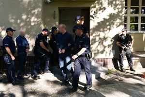 Policjanci prowadzący zatrzymanych