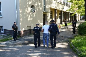 Policjanci prowadzący zatrzymanych