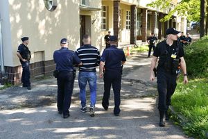 Policjanci prowadzący zatrzymanych