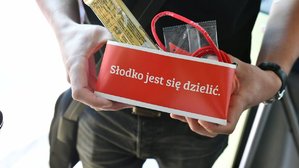 Słodycze z napisem: Słodko jest się dzielić trzymane w dłoniach