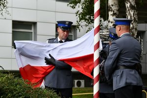 policjanci rozwijają flagę państwową