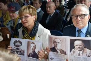 uczestnicy uroczystości trzymający w dłoniach zdjęcia poległych i pomordowanych policjantów