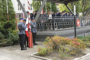 Zdjęcie kolorowe, przedstawiające policjantów niosących flagę.