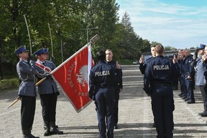 Zdjęcie kolorowe, przedstawiające policjantów z pocztem sztandarowym.