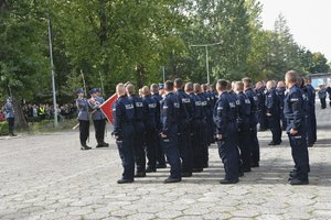 Zdjęcie kolorowe, przedstawiające policjantów z pocztem sztandarowym.