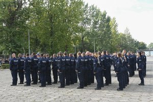 Zdjęcie kolorowe, przedstawiające policjantów z pocztem sztandarowym.