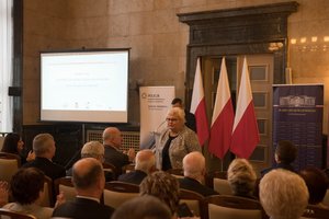 Zdjęcie kolorowe. Przedstawia uczestników konferencji, oraz poseł na Sejm RP Marię Nowak.