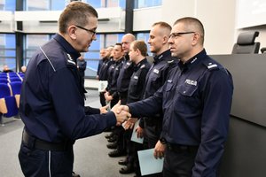 zastępca komendanta gratuluje policjantowi