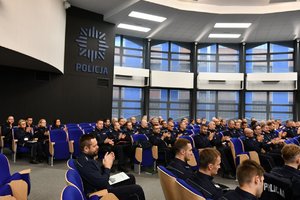 policjanci siedzący w auli, na ścianie policyjna gwiazda