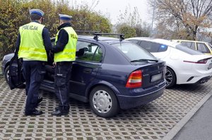 zdjęcie kolorowe: policjanci z grupy speed podczas wykonywania czynności na  drodze. Policjanci stoją przy kontrolowanym samochodzie.