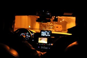 zdjęcie kolorowe: policjanci z grupy speed podczas wykonywania czynności na  drodze. widok z wnętrza radiowozu, który jedzie przez tunel.
