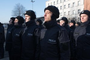 Zdjęcie kolorowe. Uroczystość ślubowania. Widoczni nowi policjanci