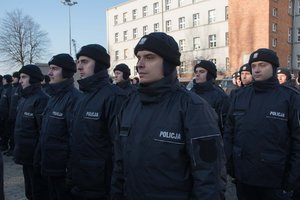 Zdjęcie kolorowe. Uroczystość ślubowania. Widoczni nowi policjanci