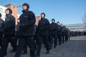 Zdjęcie kolorowe. Uroczystość ślubowania. Uroczysty przemarsz orkiestry policyjnej, kompani honorowej i nowych policjantów, zakończenie uroczystości