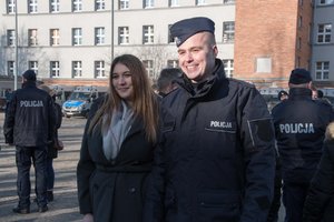 Zdjęcie kolorowe. Nowo przyjęci policjanci oraz ich rodziny i bliscy podczas pamiątkowych zdjęć