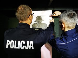 Policjanci montujący tarczę przy kulochwycie