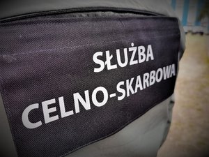 Zbliżenie na napis na kamizelce Służba Celno-Skarbowa.