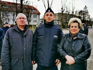 Policjant pozuje do zdjęcia razem ze swoimi rodzicami po uroczystości ślubowania.