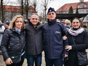 Posterunkowy Policji pozuję do zdjęcia razem z rodziną po zakończonym ślubowaniu.