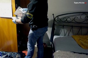 Na zdjęciu nieumundurowany policjant, który przeszukuje pomieszczenie w nocnym klubie
