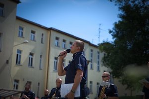 Zdjęcie kolorowe. Policjanci i policyjni muzycy występujący przed szpitalem