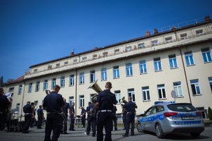 Zdjęcie kolorowe. Policjanci i policyjni muzycy występujący przed szpitalem