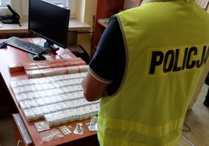 Zdjęcie kolorowe. Leżące na biurku opakowania z lekami zabezpieczonymi przez Policję