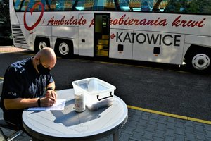 Umundurowany policjant wypełnia ankietę dotyczącą stanu zdrowia