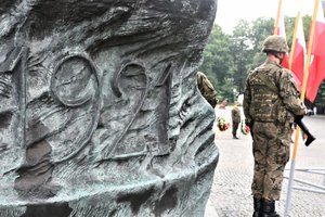 Fragment pomnika, na którym widnieje rok 1921, a przed nim stojący tyłem żołnierz