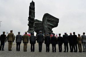 Przedstawiciele służb mundurowych stoją w szeregu przed Pomnikiem Powstańców Śląskich
