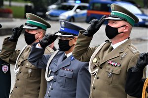 Przedstawiciele służb mundurowych, w tym Zastępca Komendanta Wojewódzkiego Policji oddają honor przed Pomnikiem Powstańców Śląskich