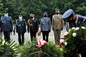 Przedstawiciele służb mundurowych, w tym Zastępca Komendanta Wojewódzkiego Policji składają wieniec przed Pomnikiem Powstańców Śląskich