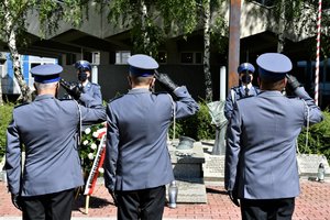 Zastępcy Komendanta Wojewódzkiego Policji w Katowicach oddający hołd, w tle złożone przed pomnik kwiaty