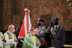 Zdjęcie kolorowe. Wnętrze kaplicy. Widoczny policyjny poczet sztandarowy oraz uczestnicy mszy.