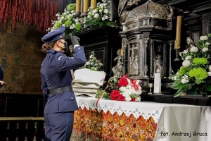 Zdjęcie kolorowe. Tablica Gloria Victis. Uroczyste złożenie kwiatów pod tablicą w obecności policyjnej warty honorowej.