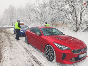 Nieoznakowany radiowóz, a obok niego policjanci.