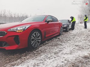 Nieoznakowany radiowóz, a za nim policjanci.