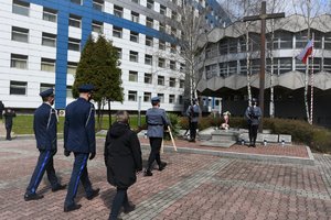 Zdjęcie kolorowe. Widoczni umundrowani policjanci i cywilna uczestniczka uroczystości przez Grobem Policjanta Polskiego na terenie KWP w Katowicach, w tym Komendant Wojewódzki Policji w Katowicach